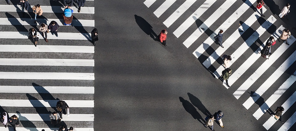 Birdsview of people walking across road crossings
